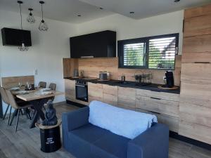 a living room with a blue couch and a kitchen at GITE DE LA PIERRE PLATE in Le Thillot