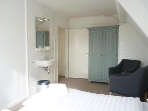 ein Badezimmer mit einem Bett, einem Waschbecken und einem Stuhl in der Unterkunft B&B Boutique Hotel De Waal in De Waal + 75 Fotos