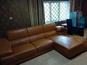 - un canapé en cuir brun dans le salon dans l'établissement Victorus Homes, à Freetown