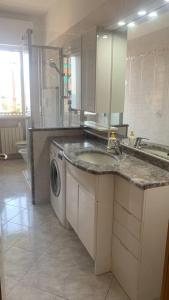 a kitchen with a sink and a washing machine at Vista mare con ogni comfort in Varazze