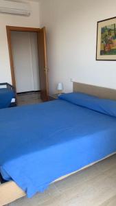 a bedroom with a bed with blue sheets and a door at Vista mare con ogni comfort in Varazze