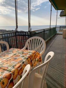 a table and chairs on a balcony with the ocean at Vista mare con ogni comfort in Varazze