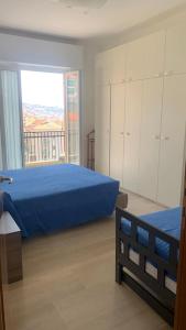 a bedroom with a blue bed and a large window at Vista mare con ogni comfort in Varazze