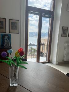 a vase of flowers sitting on a table with a window at Viromar in Naples