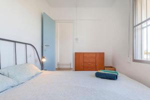 1 dormitorio con cama blanca y almohada azul en Casa Nostra on the beach, Almenara, en Almenara