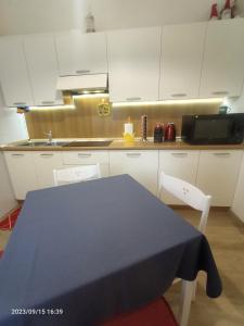 een keuken met een blauwe tafel en 2 stoelen bij Casa vacanze Piccolo in Tarvisio