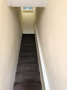 a stairway leading up to a room with a door at Spacious West London 2 Bedroom Apartment in London