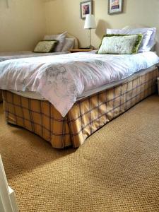a bedroom with a bed with a plkered foot board at Self catering accommodation three bedroom house or one bedroom cottage in Tomintoul