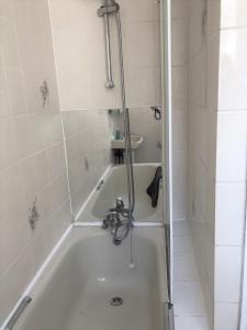 a bathroom with a bath tub with a shower at Spacious West London 2 Bedroom Apartment in London