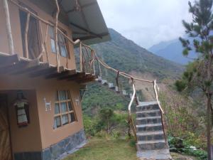 a stairway leading to a building with mountains in the background at Salkantay Hostel Chaullay in Santa Teresa
