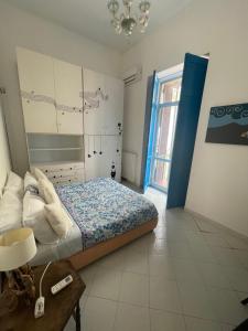 a bedroom with a bed and a table and a window at Viromar in Naples