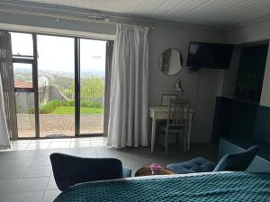 a bedroom with a bed and a sliding glass door at Welgemoed Villa in Bellville