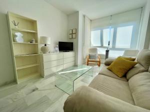 uma sala de estar com um sofá e uma mesa de vidro em Apartamento La Victoria em Córdoba