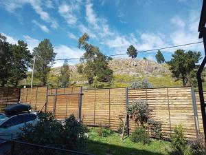 una valla de madera con una colina en el fondo en EcoHaus en la sierra en Tandil