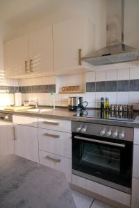 a kitchen with white cabinets and a black oven at Vesteblick-Penthouse in Coburg