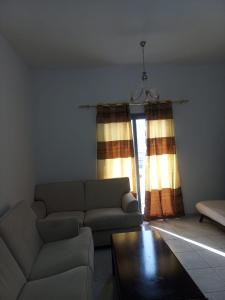 sala de estar con sofá, mesa y ventana en Holiday Home 2 Bedrooms Apartment for Family Only, en Sharjah