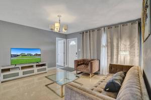 uma sala de estar com um sofá e uma televisão em Luxury 3bd/2ba near Beach & Las Olas em Fort Lauderdale