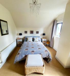 a bedroom with a large bed and a chandelier at Self catering accommodation three bedroom house or one bedroom cottage in Tomintoul