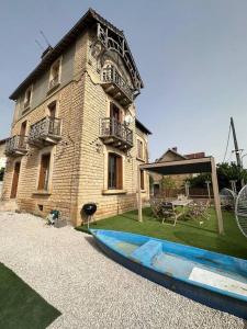 - un bâtiment avec une terrasse et une table en face dans l'établissement Maison de ville Duplex Artienzo, à Sarlat-la-Canéda