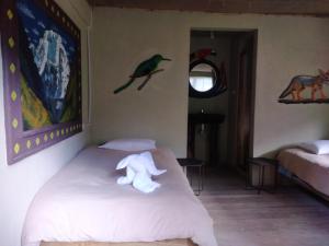 Un dormitorio con una cama con un osito de peluche. en Salkantay Hostel Chaullay, en Santa Teresa