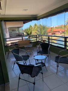 balcón con sillas, mesas y ventanas en Aquaville Resort en Aquiraz