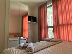 una camera con due letti e una finestra con tende rosse di Belgrade Waterfront Premium a Belgrado