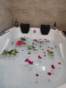 a white bath tub with flowers on the floor at SMyleINN Farm in San Fernando