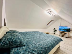 a bedroom with a bed and a flat screen tv at Altheda Living Tiny House in Suceava