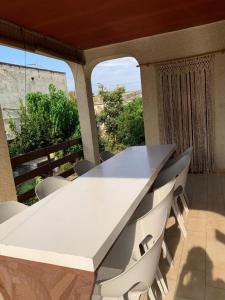- Balcón con mesa blanca y sillas en Villa Boverals, en Vinarós