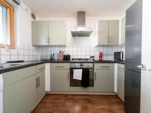 a kitchen with white cabinets and a stove top oven at Pass the Keys Sidney Street Lovely one bed flat - great base to explore London in London