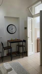 a dining room with a table and a clock on the wall at Casa Myda in Bari +22 photos