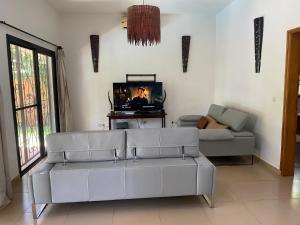 a living room with a couch and a tv at Villa Dallie in Saly Portudal