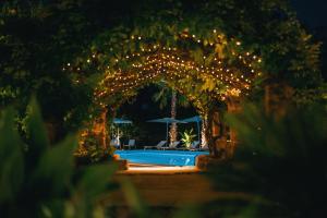 une arche avec des lumières autour d'une piscine dans l'établissement Emesh Boutique Suite, à Agrigente