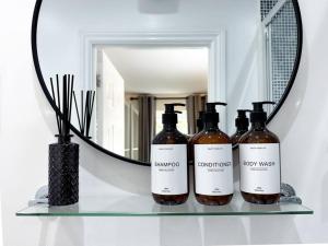 ブリストルにあるBoutique Townhouse - Sleeps up to 8 - Perfect for Families & Groups!の鏡の前の棚に置かれたワイン3本