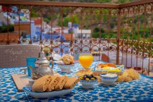 a table with breakfast food and orange juice on it at Casa Meftah Blue in Chefchaouen