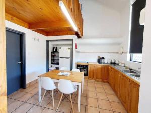 uma cozinha com uma mesa de madeira e cadeiras brancas em Carras Loft Villa Near the Sea Sleeps 5 em Mandurah