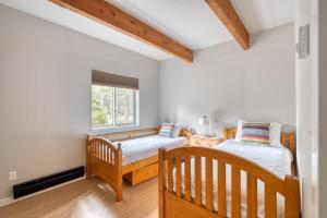 two twin beds in a room with a window at Welcome to The Village Hideout, Steps to the Village, Resort, Golf, SHARC, AC, Hot-tub, Grill and Bikes in Sunriver +47 photos