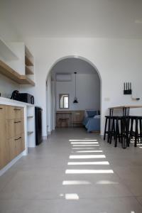 Il comprend une cuisine ouverte et un salon doté d'un canapé bleu. dans l'établissement Kotinos Luxury Suites, à Skiros