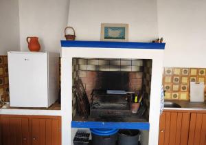 a living room with a fireplace in a kitchen at Monte da Figueira in Melides