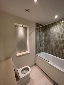 La salle de bains est pourvue de toilettes blanches et d'une baignoire. dans l'établissement Orion Building, à Birmingham