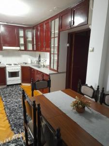 a kitchen with wooden cabinets and a wooden table at Devetka in Pirot