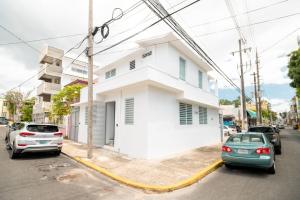 a white house with cars parked in front of it at 3 Santurce 2 Bedroom 1Bathroom Apt in San Juan