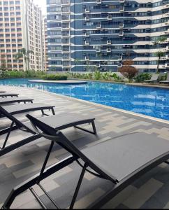 a swimming pool with lounge chairs in a building at Air Residences great location in Makati CBD in Manila