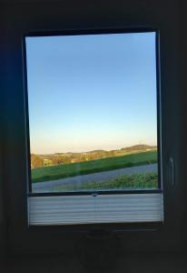 a window with a view of a field through it at Ferienwohnung Evi's Herzallerliebst in Brilon