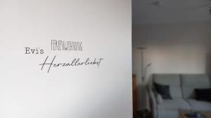 a room with a white wall with a couch at Ferienwohnung Evi's Herzallerliebst in Brilon