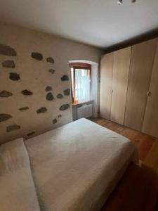 um quarto com uma cama grande e uma janela em We Love Carisolo & Pinzolo Appartamento Trilocale per 4-6 persone em Carisolo