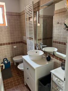 uma casa de banho com um lavatório branco e um WC. em We Love Carisolo & Pinzolo Appartamento Trilocale per 4-6 persone em Carisolo