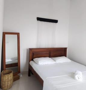 1 dormitorio con 2 camas y espejo en Desire Village Rakwana, en Rakwana