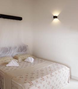 1 dormitorio con 2 camas y una luz en la pared en Desire Village Rakwana, en Rakwana