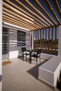 a patio with a table and chairs and a balcony at Kotinos Luxury Suites in Skiros